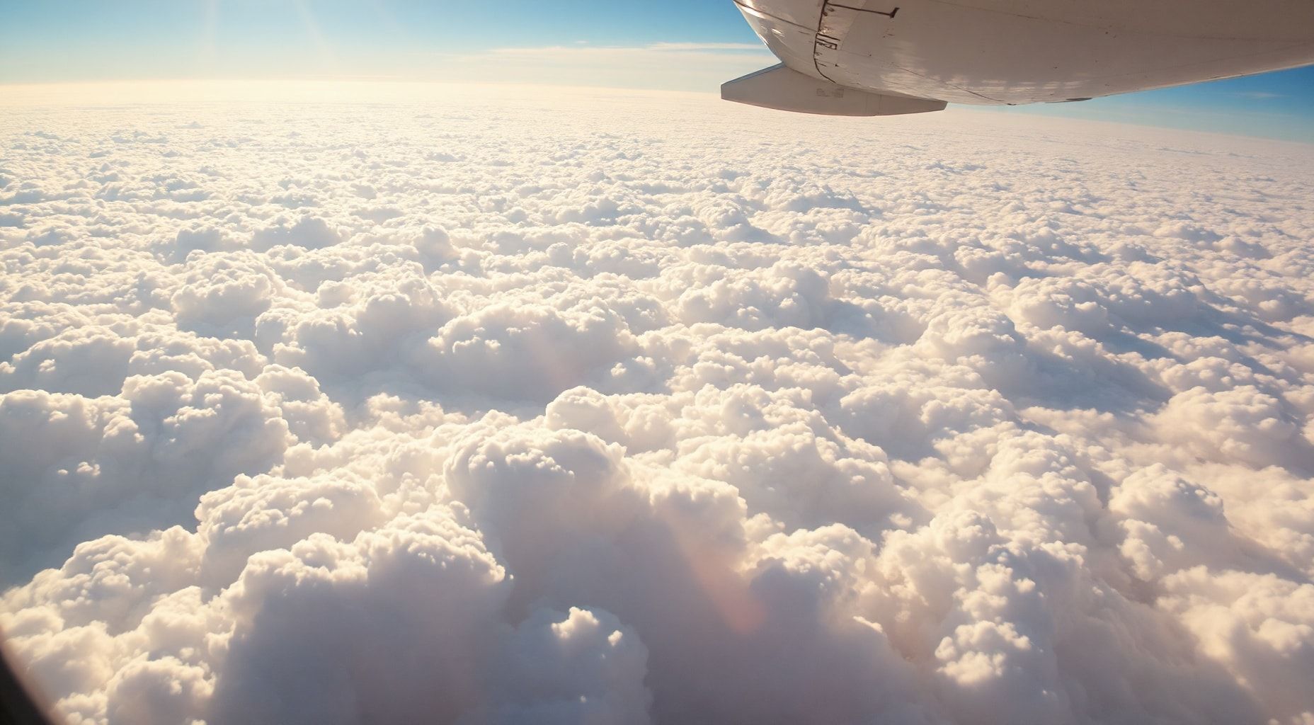 Download Fluffy White Clouds From Airplane Wallpaper